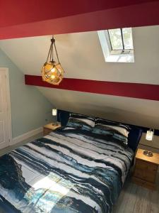 a bedroom with a bed with a red stripe on the wall at The Coach House 1861 in Penrith