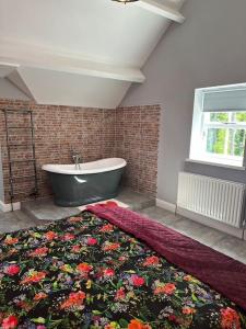 a bathroom with a bath tub and a flower rug at The Coach House 1861 in Penrith