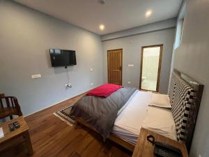 een slaapkamer met een bed en een flatscreen-tv bij Honey Bee in Leh