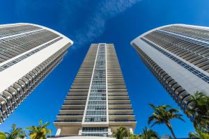 two tall buildings against a blue sky with palm trees at Picturesque Beachfront Condo #4105 - LOVELY 2BD and 2BA PENTHOUSE WITH DIRECT OCEAN VIEW in Hollywood