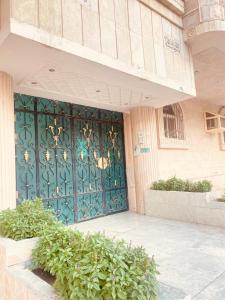 a green door on the side of a building at شقة فندقية استديو بطحاءقريش مكة in Makkah