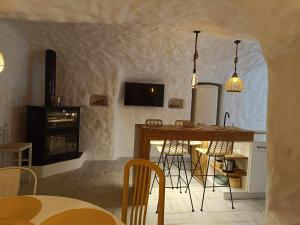 cocina con mesa, sillas y chimenea en Cueva OTTO Familiar Privada, en Baza