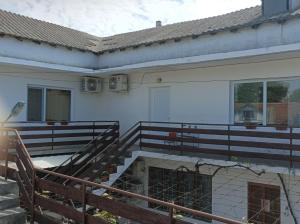 a white building with stairs and a balcony at Къща за гости Бяла Къща in Kavarna