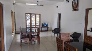 a living room with a table and chairs and a television at The Village Courtyard- Organic farm & homestay in Pīrmed