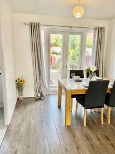 a dining room with a wooden table and chairs at The Herald House Dartford 3 Bedroom Apartment in Kent