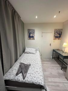 a small bedroom with a bed and a desk at Guest&Rest 3 in London