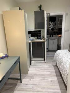 a room with a kitchen and a room with a bed at Guest&Rest 3 in London