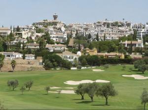 un campo de golf con árboles y edificios al fondo en Luxury Suites Fuengirola, en Fuengirola