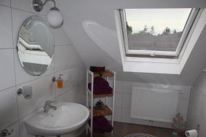 a bathroom with a sink and a mirror and a window at Pension Mimosa in Rust