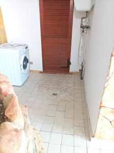 a bathroom with a washing machine and a door at Sardinia Yellow House in Solanas