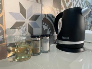 a coffee maker and two glass containers on a counter at Cabañas Raupa in Hanga Roa