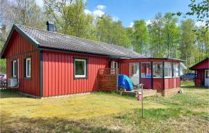 czerwony dom z werandą i dziedzińcem w obiekcie Amazing Home In Ljungby With Harbor View w mieście Ljungby
