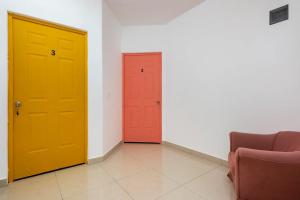 dos puertas amarillas y rojas en una habitación en Beautiful Apartment surrounded by nature w/Pool, en Cancún