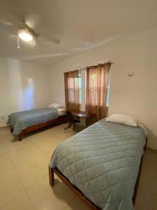 1 dormitorio con 2 camas y escritorio. en Beautiful Apartment surrounded by nature w/Pool, en Cancún