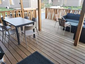 a patio with a table and chairs on a deck at Chez Christian Chalet aux bords du lac de Peyre in Labouheyre