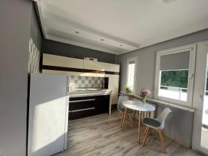 a kitchen with a refrigerator and a table and chairs at Apartament blisko morza in Gdynia