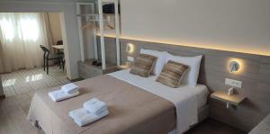 a bedroom with a large bed with towels on it at Sea Breeze in Kalamaki Chanion