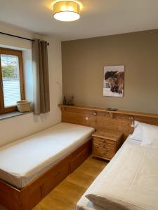 1 dormitorio con 2 camas y ventana en Ferienwohnung Martina Bauer, en Oberammergau