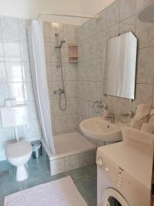 uma casa de banho com um chuveiro, um WC e um lavatório. em Apartment Antonia em Vodice