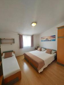 um quarto de hotel com duas camas e uma janela em Apartment Antonia em Vodice