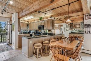 a kitchen with a table and chairs and a counter at Interlude Condominiums 2-Bedroom Unit 209 in Snowmass Village