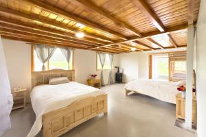 2 letti in una camera da letto con soffitti in legno di Ilinizas Mountain Lodge a Chaupi