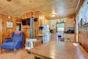 cocina con mesa y fogones en Charlevoix Cabin with Patio and Grill - Steps to Lake! en Charlevoix