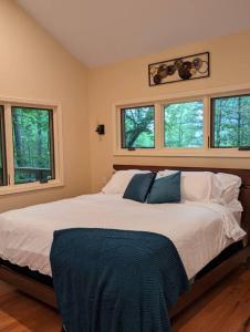 1 dormitorio con 1 cama blanca grande y ventanas en Oak Treehouse Cabin Rustic Luxury Near Asheville, en Marshall
