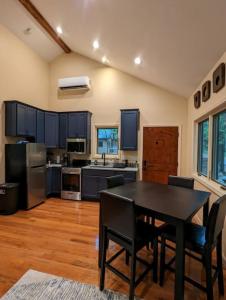 una cocina con mesa negra y sillas negras en Oak Treehouse Cabin Rustic Luxury Near Asheville, en Marshall