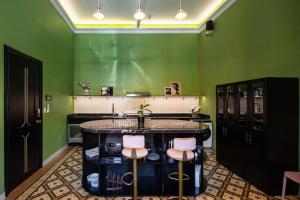 uma sala verde com um bar com dois bancos em HOLT's Casa De Mi Independencia em Oaxaca de Juárez
