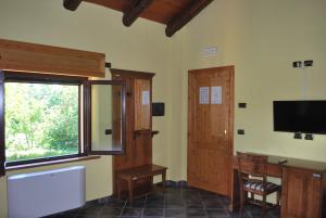 Zimmer mit einem großen Fenster und einem TV an der Wand in der Unterkunft Agriturismo Roseto in Serra San Bruno