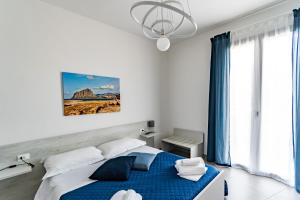 una camera con letto blu e lampadario a braccio di Appartamenti Petali Di Rosa a Custonaci