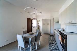 una cucina e una sala da pranzo con tavolo e sedie di Appartamenti Petali Di Rosa a Custonaci