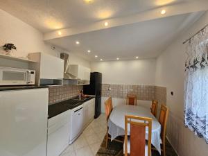 eine kleine Küche mit einem Tisch und einer Mikrowelle in der Unterkunft Apartment Topalović in Korenica