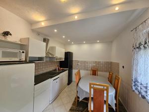 a small kitchen with a table and a microwave at Apartment Topalovic Plitvice Private Pool in Korenica