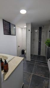 a bathroom with a shower and a sink and a toilet at UKU INN in Medellín