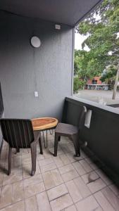 a table and chairs on a patio with a window at UKU INN in Medellín