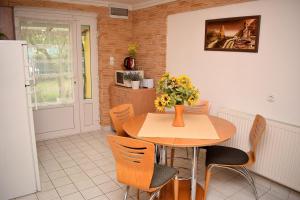 un comedor con una mesa y sillas con flores. en Liliom Apartman, en Balatonvilágos