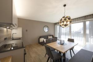 cocina y sala de estar con mesa y sofá. en Residence Sonja - Apartment Fagus, en Rablà
