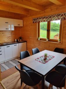 a kitchen and dining room with a table and chairs at Blask Jeziora in Frydman