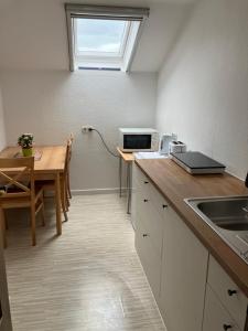 a kitchen with a table and a window on the wall at Private Studio Apartment with Balcony in Dortmund-Brackel in Dortmund