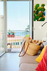 a basket sitting on a couch in front of a window at Riflessi DaMare Room & Apartment in Salerno