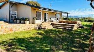 une maison avec un mur en pierre et une terrasse dans l'établissement Primo farm, à Paarl