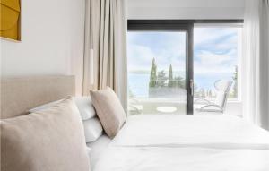 a bedroom with a bed and a large window at Gorgeous Home In Dramalj in Dramalj