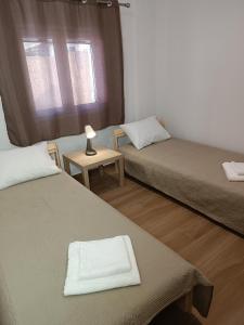 Zimmer mit 2 Betten und einer Lampe auf einem Tisch in der Unterkunft Selinia Residence in Selínia
