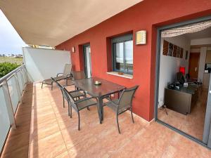 a patio with a table and chairs on a balcony at Salicornia apartament in L'Eucaliptus