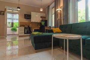 a living room with a green couch and a table at Apartament GRACJA w Jedlinie Zdrój in Jedlina-Zdrój