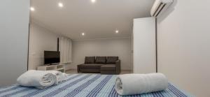 1 dormitorio con sofá y 1 cama con toallas en Villas Sport And Beach en Fanusa