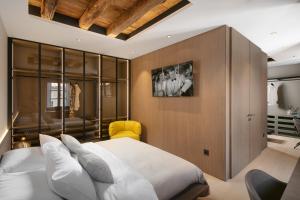 a bedroom with a white bed and a yellow chair at Villa Lapisa in Dubrovnik