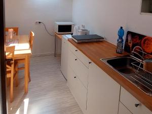 a kitchen with a counter with a sink and a table at Private Studio Apartment with Balcony in Dortmund-Brackel in Dortmund